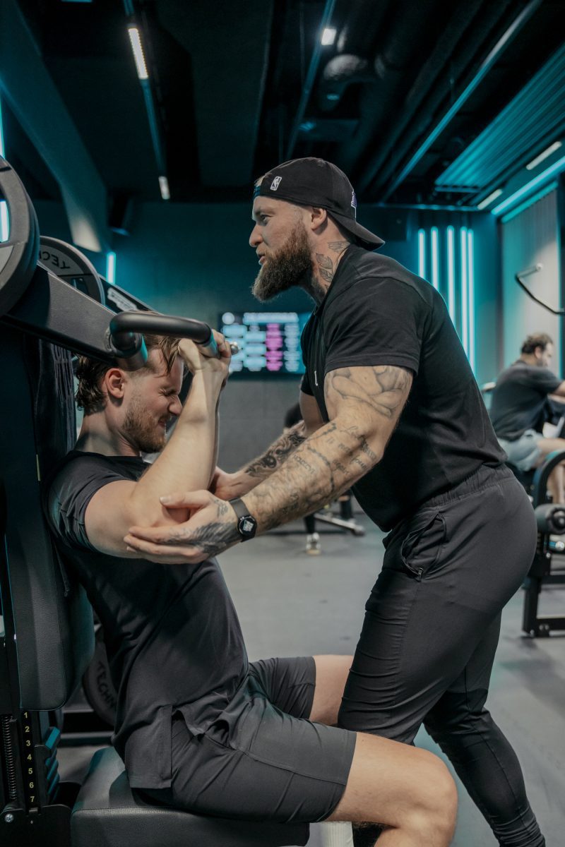 Mann und Trainer beim Krafttraining.