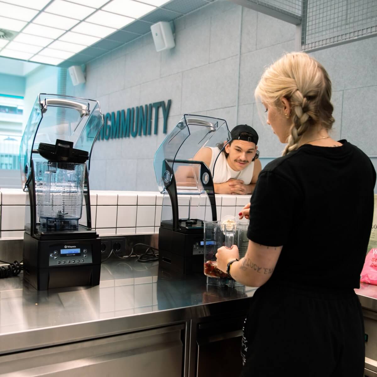 Personal Group Trainerin macht für Kunden einen Smoothie an der Wet Bar im King Kong Club Salzburg.