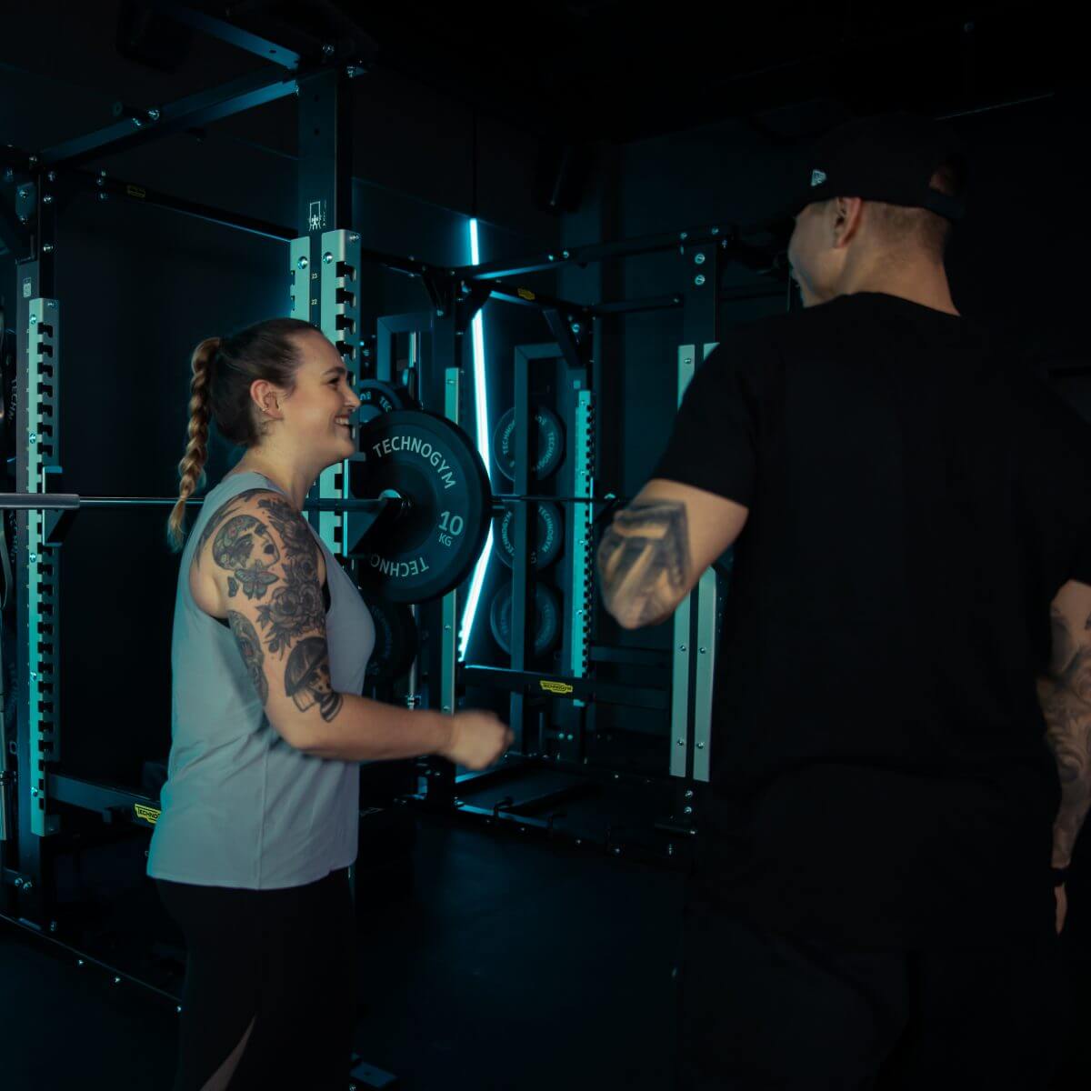 Coach und Mitglied lachen im King Kong Club während Fitnesskurs.