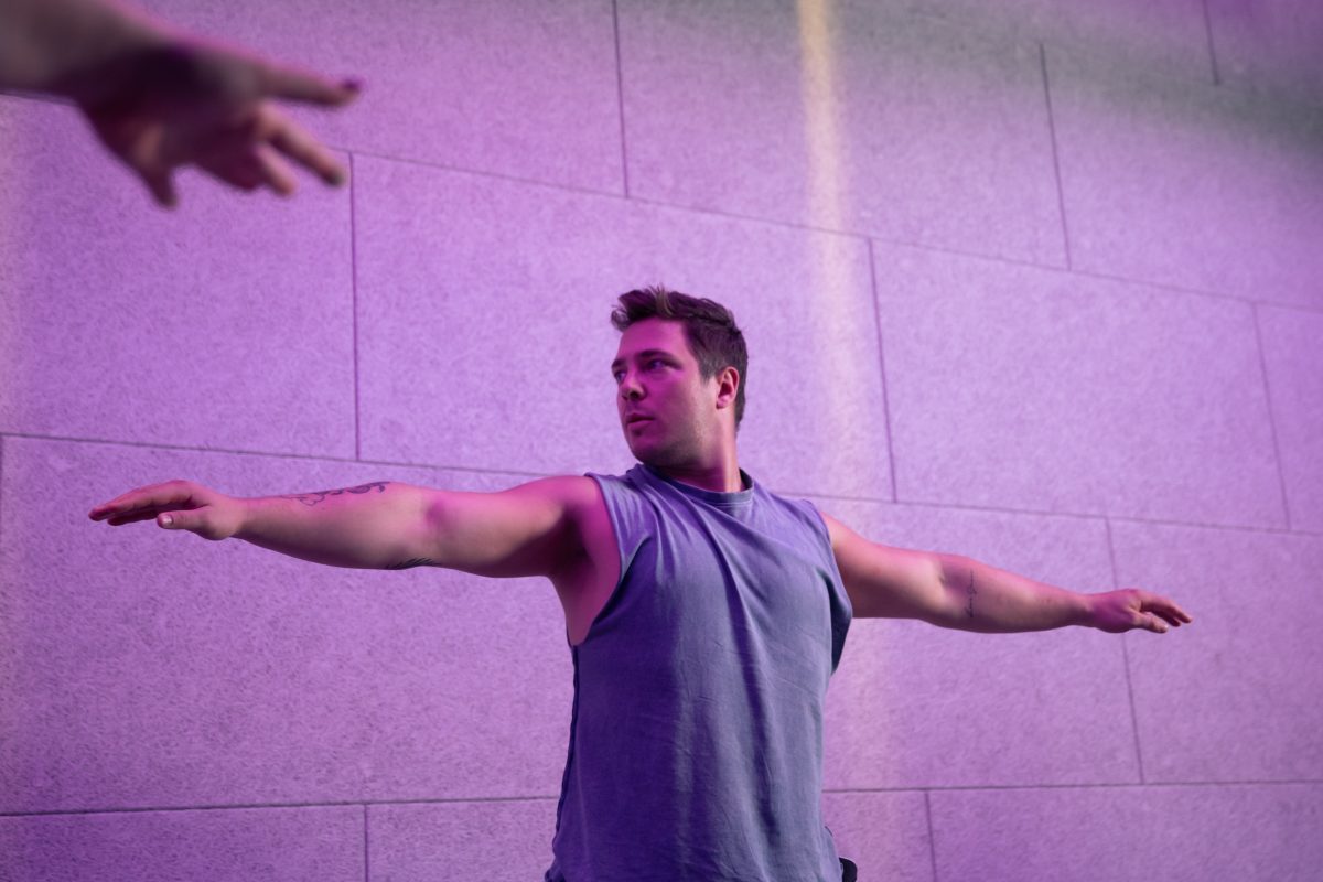 Mann macht Yoga Übungen und streckt seine Hände dazu vom Körper weg