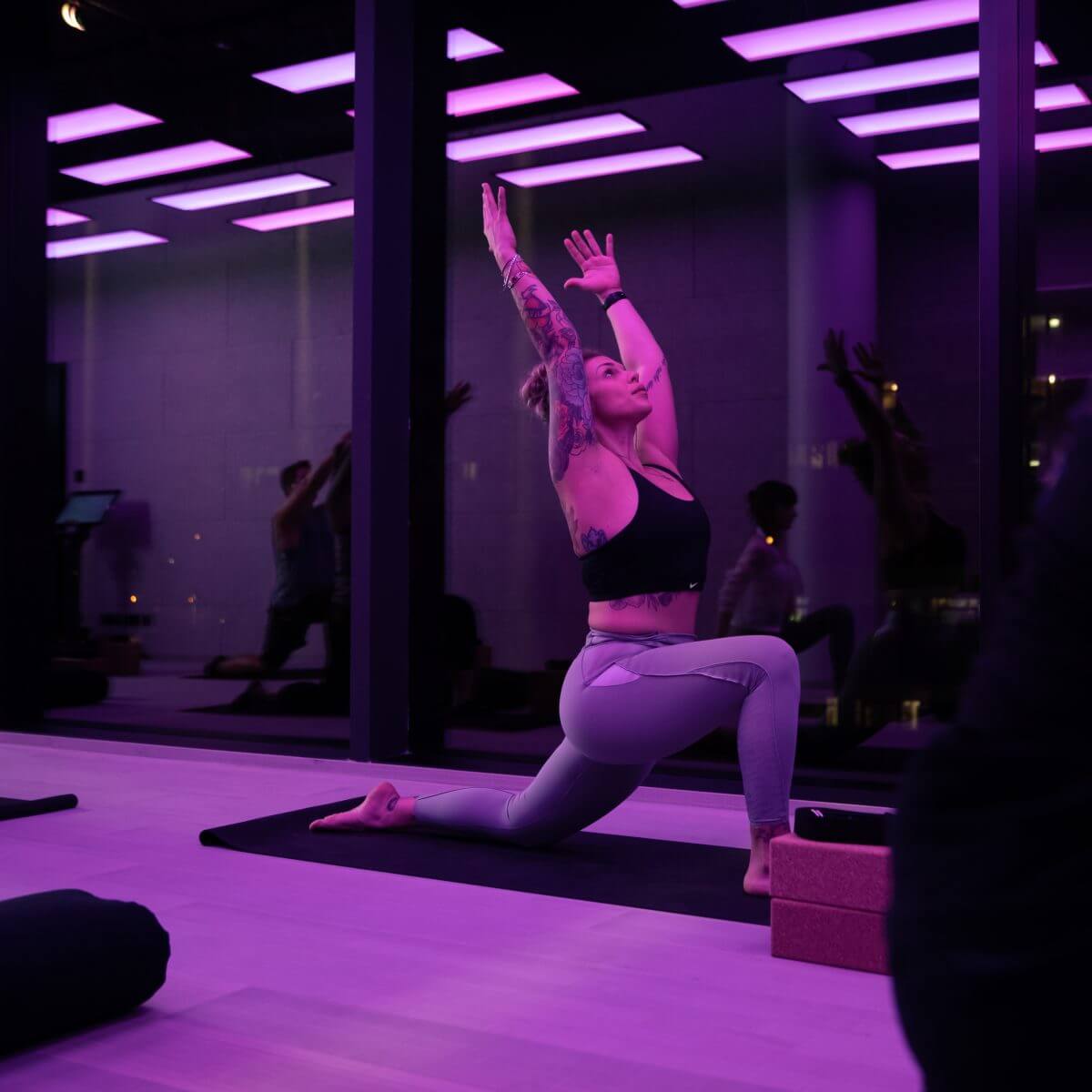 Frau führt Yogaübung auf Yogamatte im King Kong Club Salzburg aus.