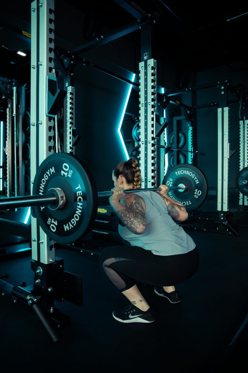 Frau stemmt Gewichte beim Krafttraining im King Kong Club Salzburg.