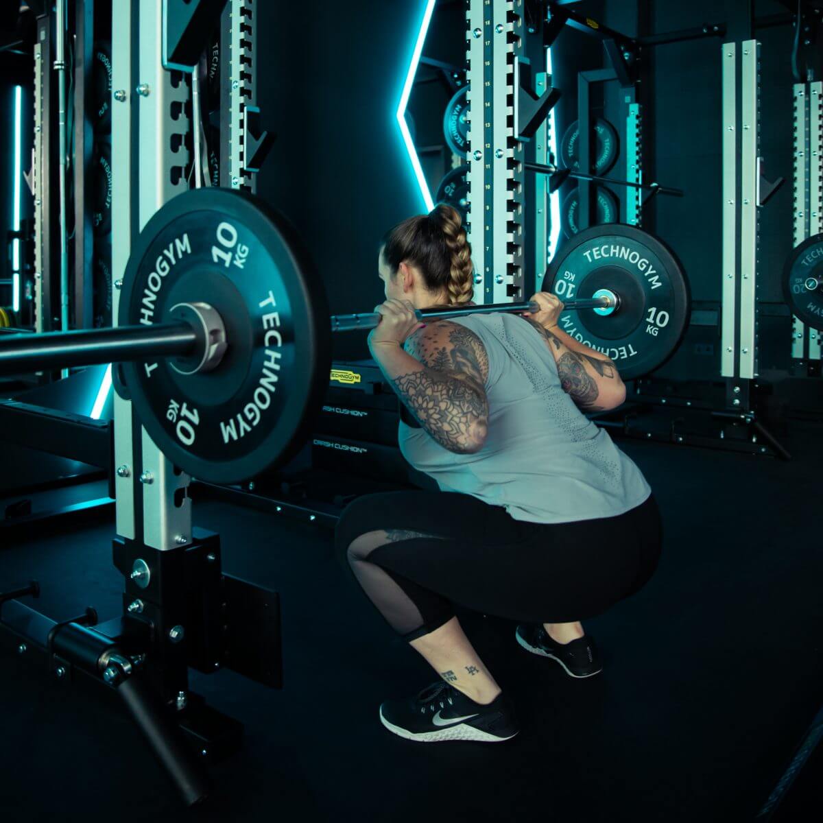 Frau stemmt Gewichte beim Krafttraining im King Kong Club Salzburg.
