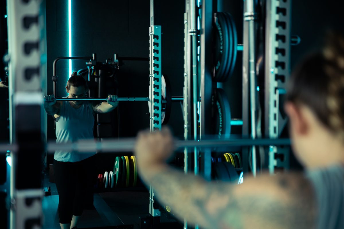 Frau beim Ausführen von Kraftübungen an Fitnessgerät im King Kong Club Salzburg.