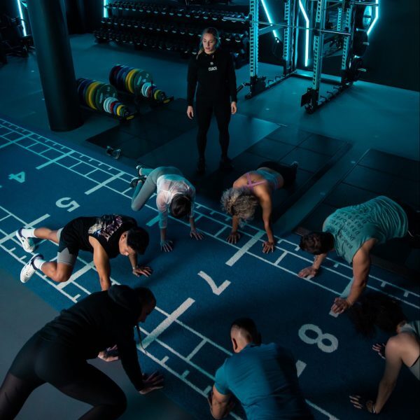 Trainierende im Personal Group Fitnesskurs unter Anleitung von weiblichem Coach im King King Club Salzburg.