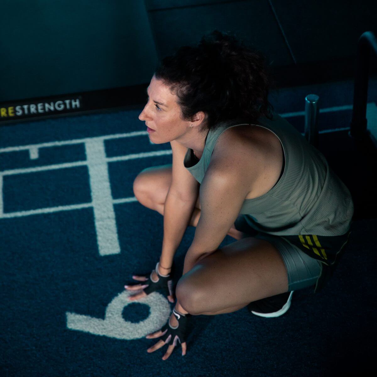 Frau hockalt am Boxen und macht sich zum Sprint bereit im King Kong Club