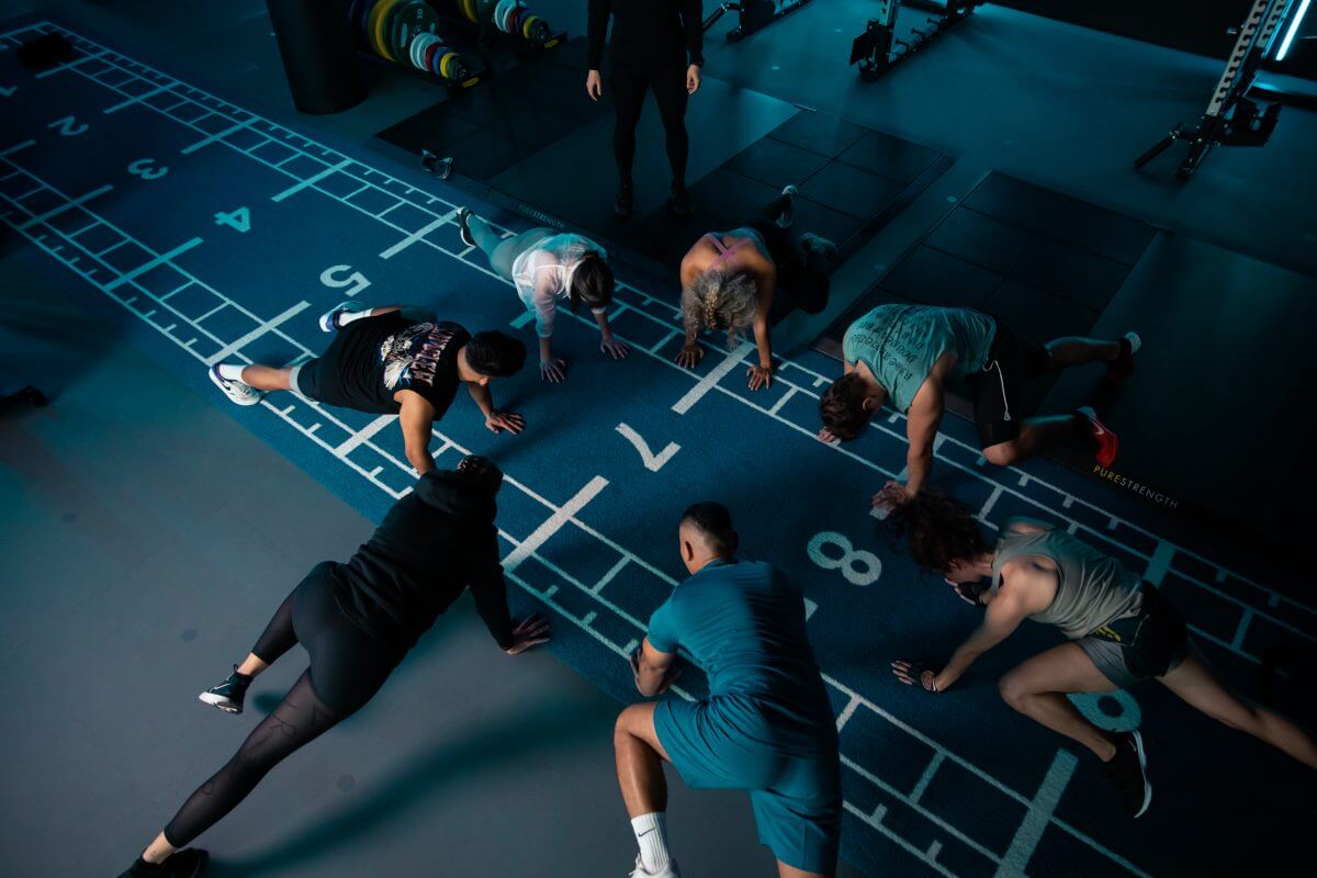 Mehrere Personen machen Liegestütze zum Aufwärmen im King Kong Club