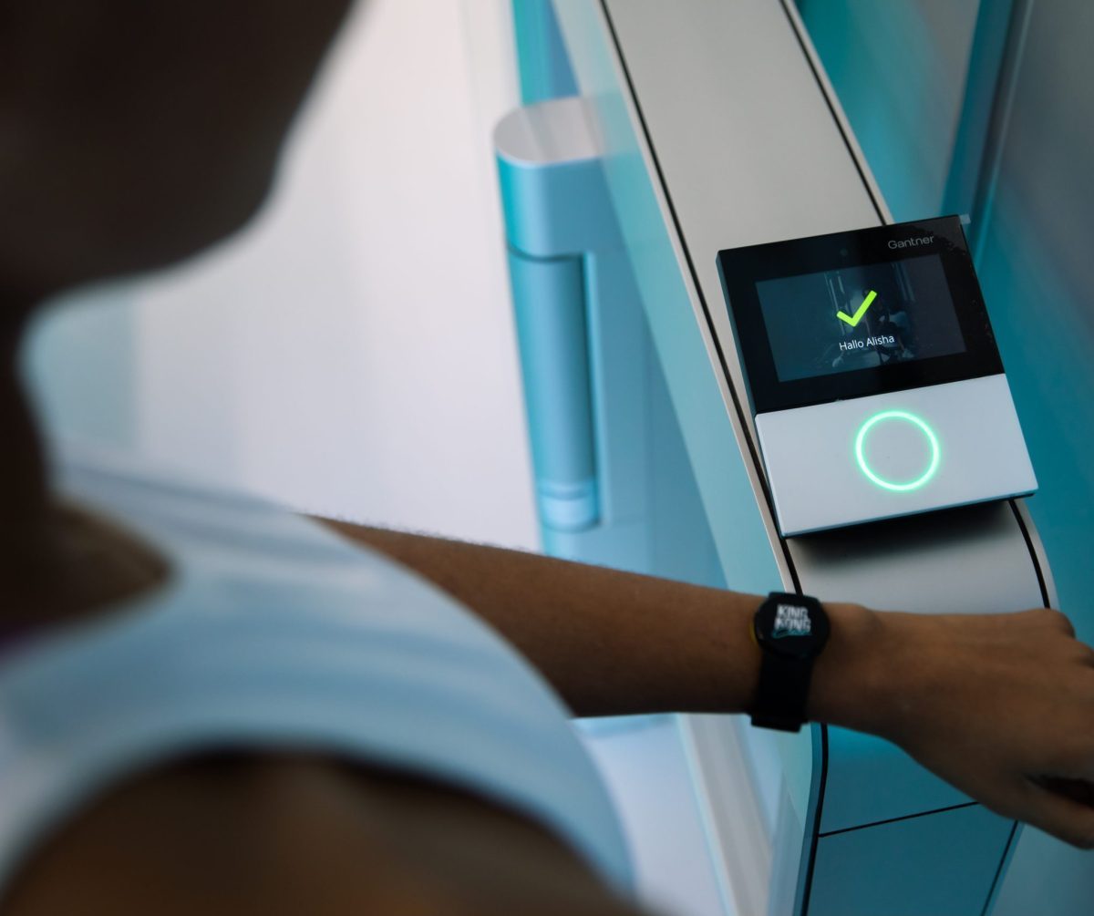 Mitglied vom King Kong Club hält elektronisches Membership Band an Eingangscheck-in um in den Fitnessclub zu kommen.