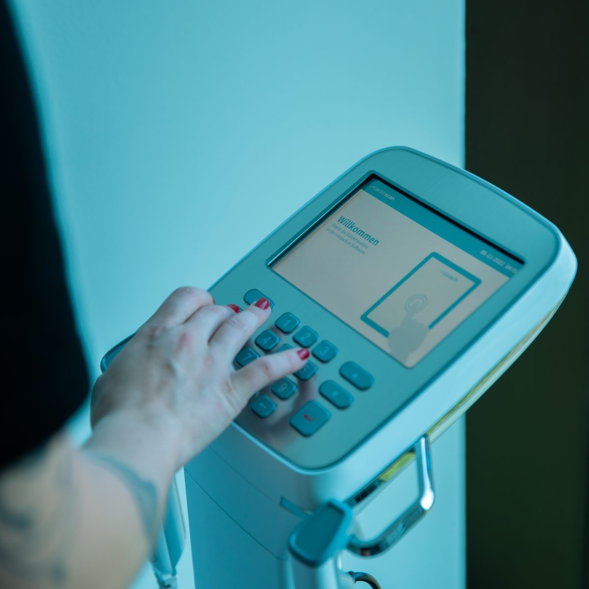 Weibliche Hand beim Bedienen eines Fitnessmessgerätes zur BIA Analyse im King Kong Club Salzburg.